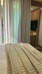 a large blanket on a bed in a bedroom at Vista Azul Apart Hotel in Frutal +1 photo