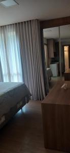 a bedroom with a bed and a window with curtains at Vista Azul Apart Hotel in Frutal