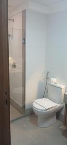 a white bathroom with a toilet and a shower at Vista Azul Apart Hotel in Frutal