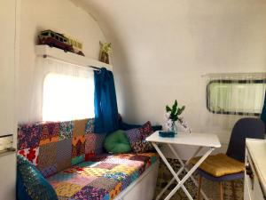 a living room with a couch and a table at Glamping du loup garou in Bléré