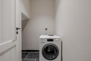 a washing machine in a room with a white wall at Haus Hyggelig in List