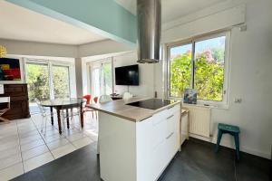 una cucina con un lavello e un tavolo di Maison lumineuse avec jardin à 50m de la mer a Larmor-Plage