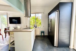 una cucina con frigorifero in acciaio inossidabile e bancone di Maison lumineuse avec jardin à 50m de la mer a Larmor-Plage