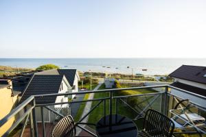 a balcony with chairs and a view of the ocean at NORDA in Kuźnica