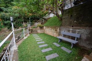 a bench sitting in the grass next to a building at The Tranquil Cabana - kandy in Rattanadeniya +1 photo