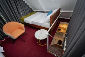 a small room with a bed and a chair at The Tranquil Cabana - kandy in Rattanadeniya