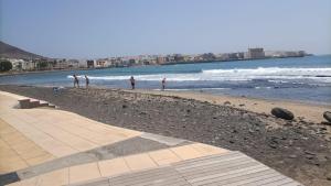 un grupo de personas en una playa cerca del agua en Brisa C, en Agüimes