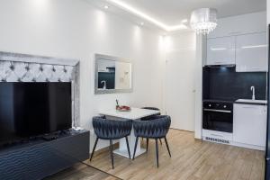 a kitchen with a table and two chairs and a television at Rebany Apartman 2 Free parking, Central Location in Debrecen +26 photos