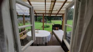a porch with a table and a view of a yard at Pirkia Miške in Kazitiškis +19 photos