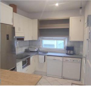 eine kleine Küche mit weißen Schränken und einem Fenster in der Unterkunft Apartamento El Olivar in San Sebastián