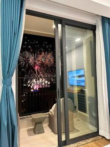 a room with a window with a view of a fireworks display at Hillside residence Phu Quoc, sea &firework view in Phu Quoc