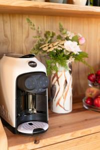 a toaster and a vase with flowers on a shelf at Etna Glamping in Milo