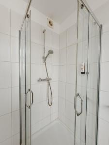 a shower with a glass enclosure in a bathroom at SAFIR by Domani Hotels in Aalst +3 photos