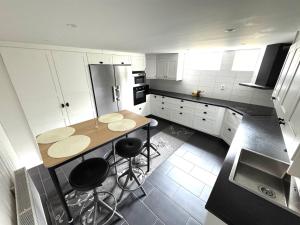 a kitchen with a table and two stools in it at Fredholmsvillan kärra in Gothenburg