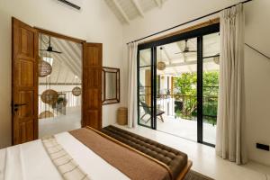 a bedroom with a bed and a large window at Terrene Villa in Weligama