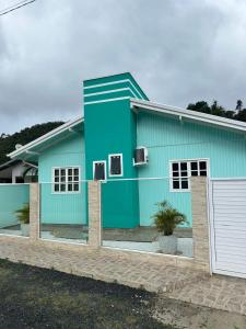 a blue house with a white at Casa Alegria com Piscina in Barracão