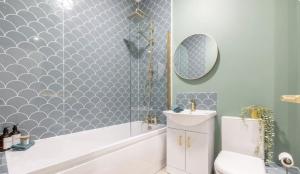 a bathroom with a tub and a toilet and a sink at Beautiful townhouse in Carrickfergus