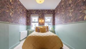 a bedroom with a bed in a room with wallpaper at Beautiful townhouse in Carrickfergus
