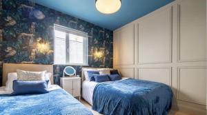 a bedroom with two beds and a wall mural at Beautiful townhouse in Carrickfergus
