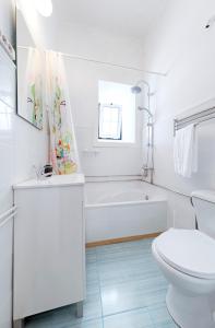 bagno bianco con vasca e servizi igienici di Ponto de Abrigo ad Aveiro