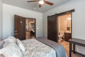 Un dormitorio con una cama y un ventilador de techo. en Modern Stay Near Jack Trice Stadium - Walk to ISU, en Ames