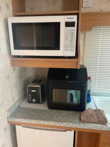 eine Mikrowelle und ein Toaster auf der Theke in der Unterkunft Static Caravan in Aberystwyth