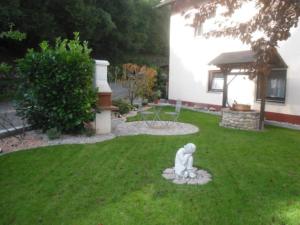 una estatua sentada en el patio de una casa en Ferienwohnung Zapf en Forbach