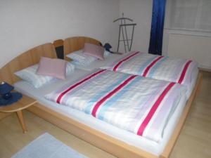 1 cama grande con sábanas y almohadas coloridas. en Ferienwohnung Zapf en Forbach