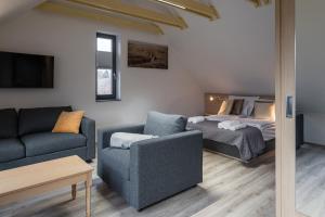 a living room with a bed and a couch at STADIUM HOME Panzió in Németbarnag