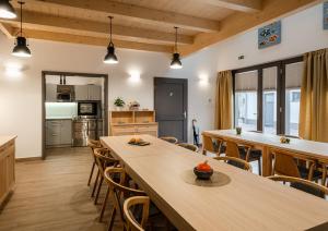 a kitchen and dining room with wooden tables and chairs at STADIUM HOME Panzió in Németbarnag +20 photos