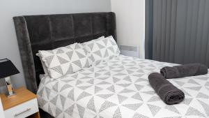 - un lit avec une couette et des oreillers en noir et blanc dans l'établissement Cozy Modern Apt MCR City Centre, à Manchester