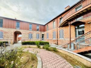 a brick building with a walkway in front of it at Deltasol in Montepulciano