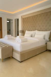 a large bedroom with a large white bed and a chair at Villa Jasmin 15 in M'diq