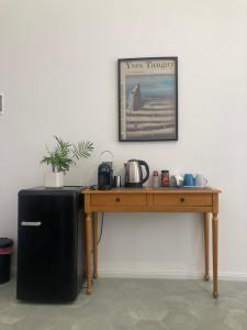a wooden table with a refrigerator and a picture on the wall at Casa Makarina - Camere centro storico in Mazzarino
