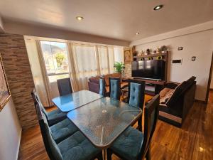 una sala da pranzo con tavolo, sedie e televisione di Las Margaritas Apart3 a San Sebastián