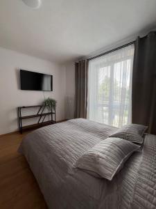 a bedroom with a bed with a large window at Apartnám Sysel in Martin