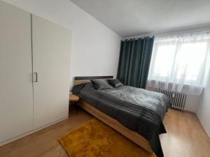 a bedroom with a bed and a large window at Apartmán SYSEĽ in Martin