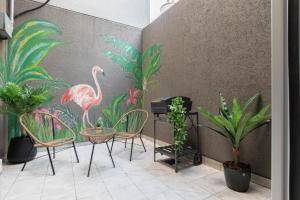 ein Raum mit einem Tisch und Stühlen und einem Gemälde von Flamingos in der Unterkunft Fliphaus Gregoria Perez 3500 'A' - 1 Bd Patio & BBQ Colegiales in Buenos Aires