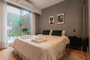 ein Schlafzimmer mit einem großen Bett mit Handtüchern darauf in der Unterkunft Fliphaus Gregoria Perez 3500 'A' - 1 Bd Patio & BBQ Colegiales in Buenos Aires