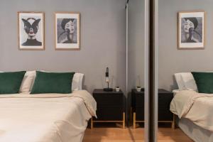 ein Schlafzimmer mit zwei Betten und einem Spiegel in der Unterkunft Fliphaus Gregoria Perez 3500 'A' - 1 Bd Patio & BBQ Colegiales in Buenos Aires + 4 Fotos