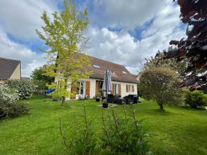 una casa con un cortile con erba verde di Villa Coubertin - Premium - 7 pers a La Rivière-de-Corps