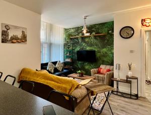 a living room with a green wall with a couch at 2 Bedroom Flat Oak in Town Center Wellingborough in Wellingborough