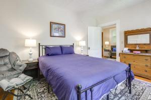 a bedroom with a purple bed and a chair at 2-Acre Property Victorian Home in Brownville! in Brownville