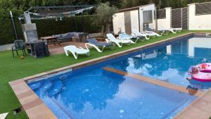 an empty swimming pool with chairs and a patio at Alma in La Canyera