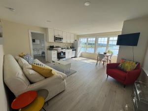 un soggiorno con divano bianco e sedia rossa di Acadia Horizon Cottage a Southwest Harbor