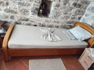 a bed in a room with a stone wall at villa bilimots in Érimos