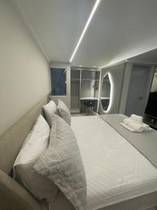 a bedroom with a large bed with white sheets and pillows at Troodon Park Hotel in Sousa