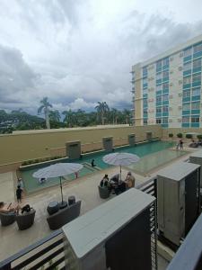 BayabasanDongStay的游泳池,游泳池里有人坐在雨伞下