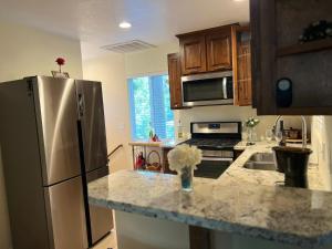 eine Küche mit einem Kühlschrank aus Edelstahl und einer Theke in der Unterkunft Cozy Cabin in Crestline