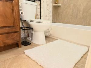 ein Badezimmer mit einem WC und einem weißen Teppich in der Unterkunft Cozy Cabin in Crestline + 20 Fotos